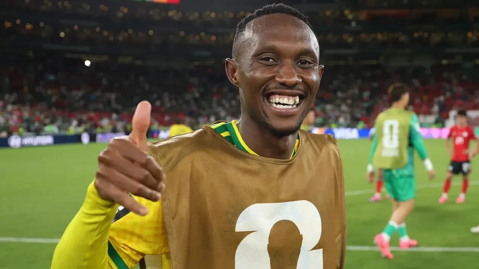 Jugador sonriente haciendo gesto de aprobación en el campo