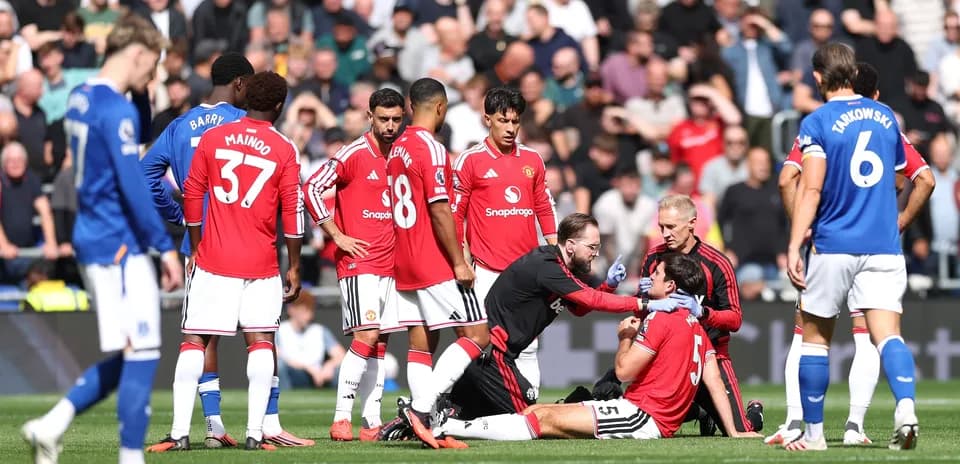 Jugadores de Manchester United rodeando a jugador lesionado