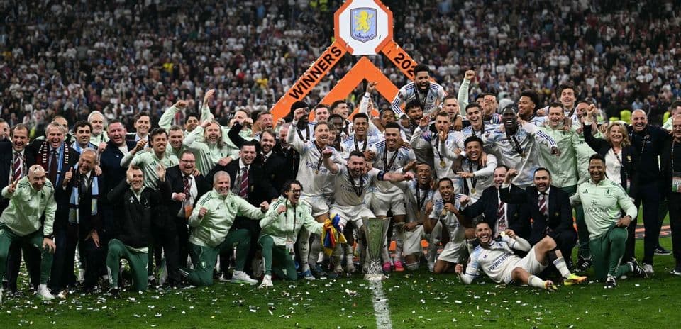 Equipo celebrando con trofeo en el campo