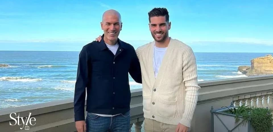 Dos hombres posando frente al mar en un balcón