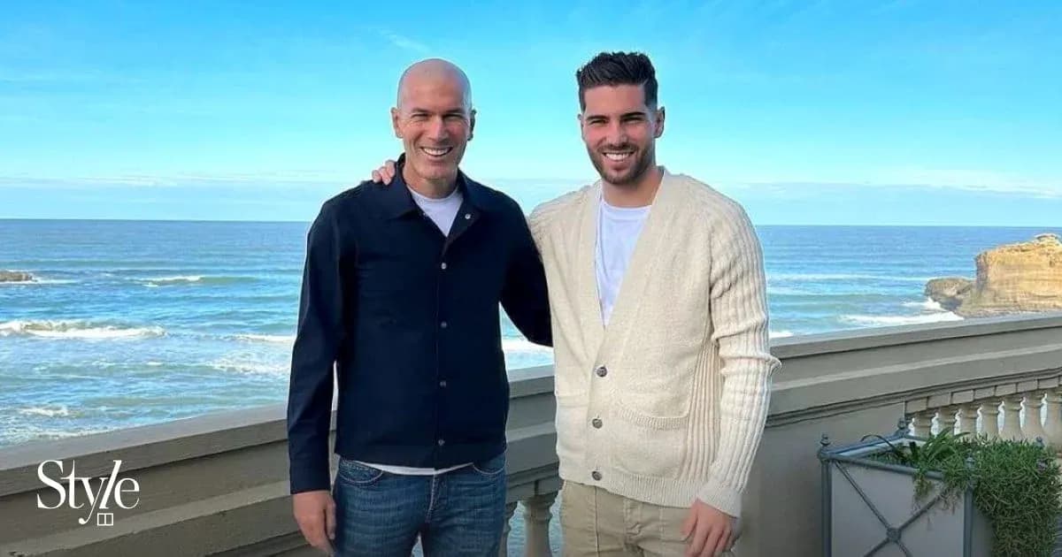 Dos hombres posando frente al mar en un balcón