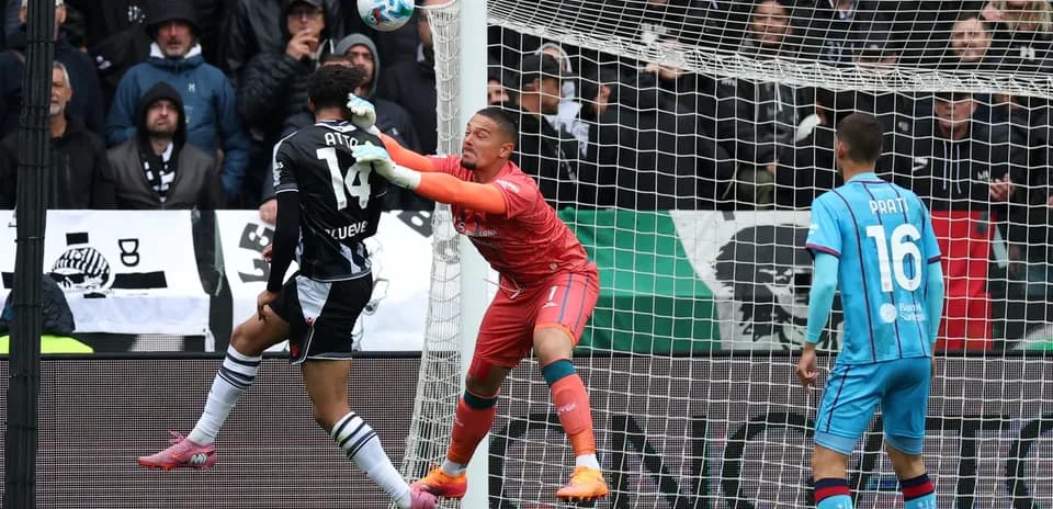 Portero deteniendo el balón en el partido