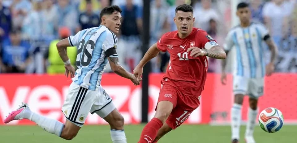 Jugador suizo driblando a defensor argentino en partido