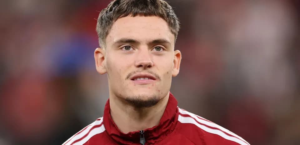 Jugador en chaqueta roja durante el calentamiento