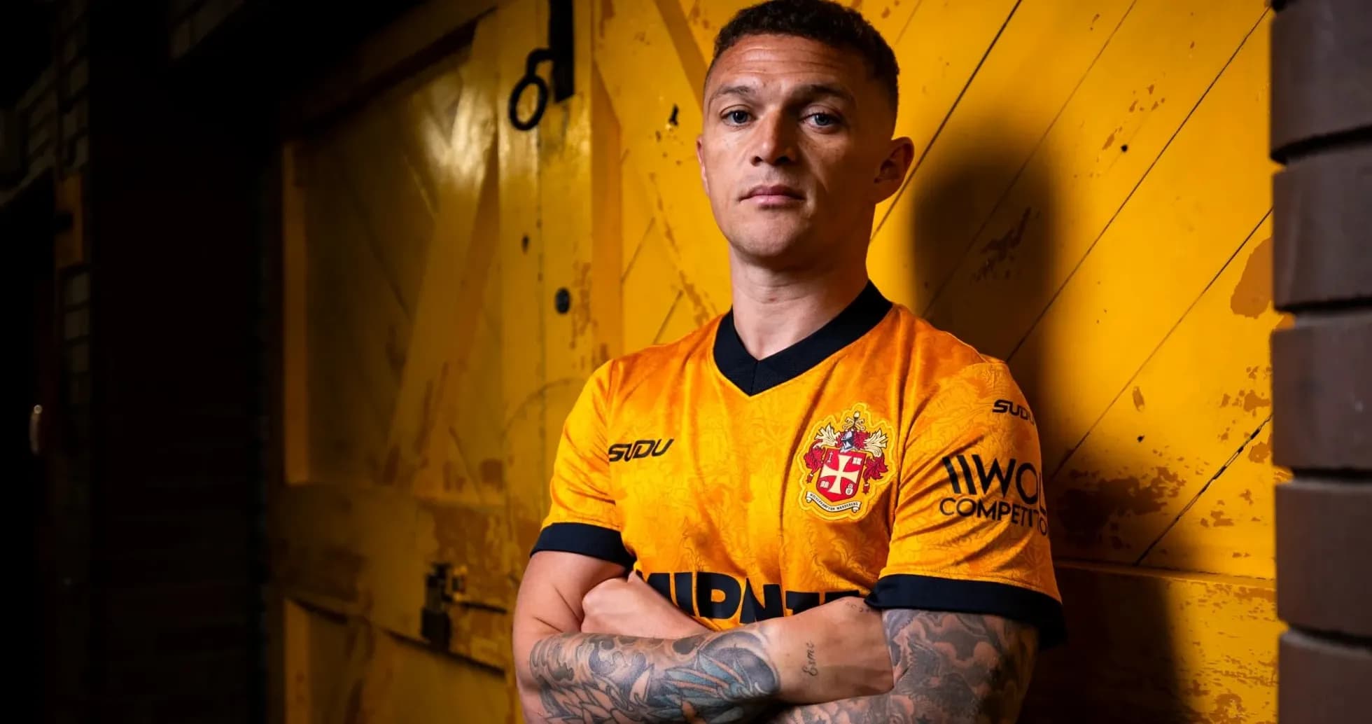 Jugador posando en camiseta amarilla con fondo amarillo