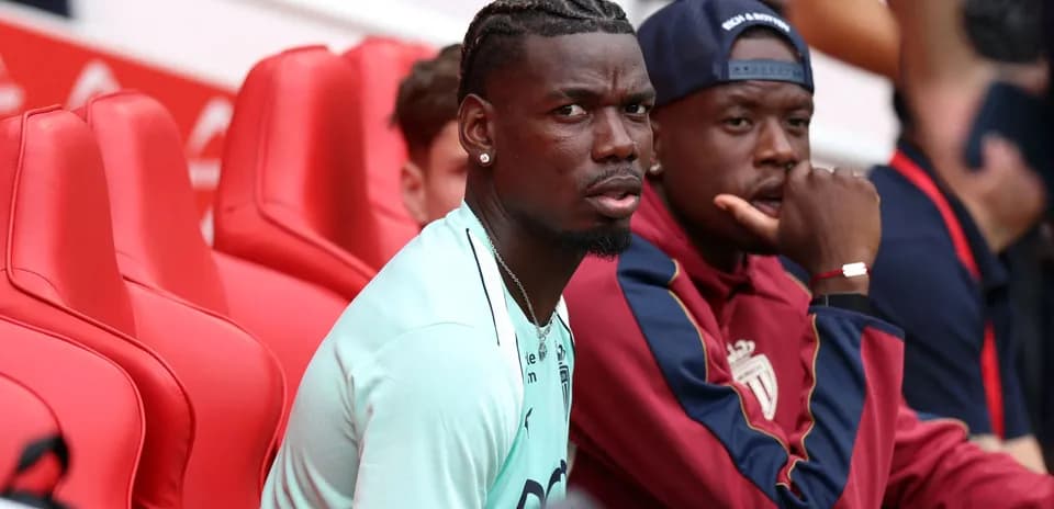 Paul Pogba y compañero sentados en banquillo