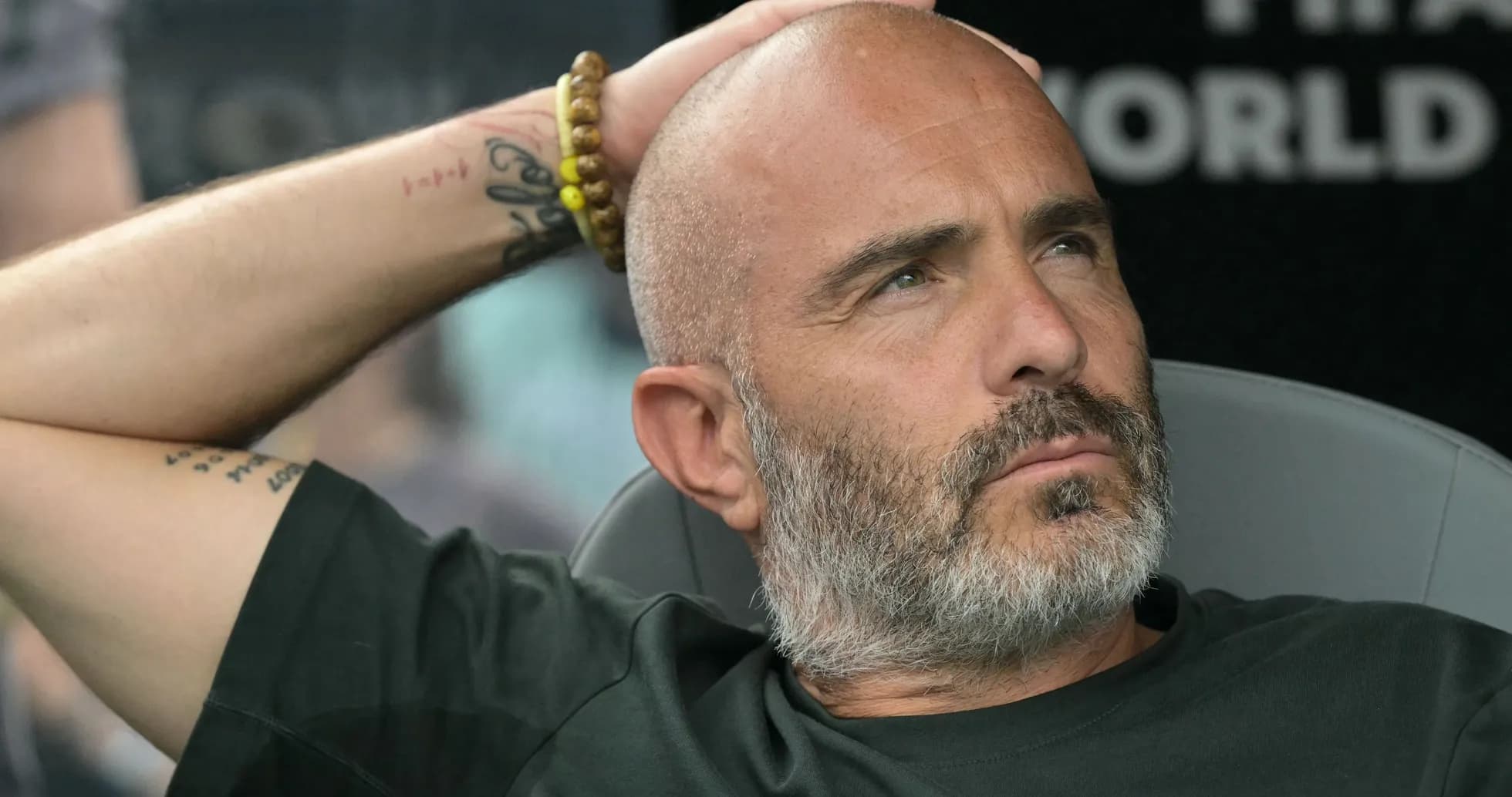 Entrenador sentado con mano en la cabeza