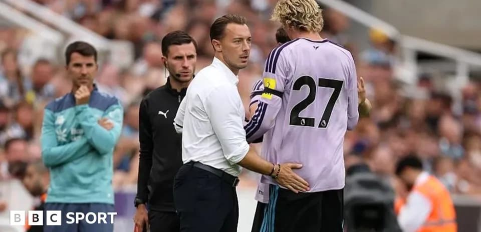 Entrenador hablando con portero en el banquillo