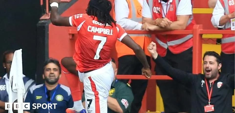 Jugador celebrando un gol con aficionados en el estadio