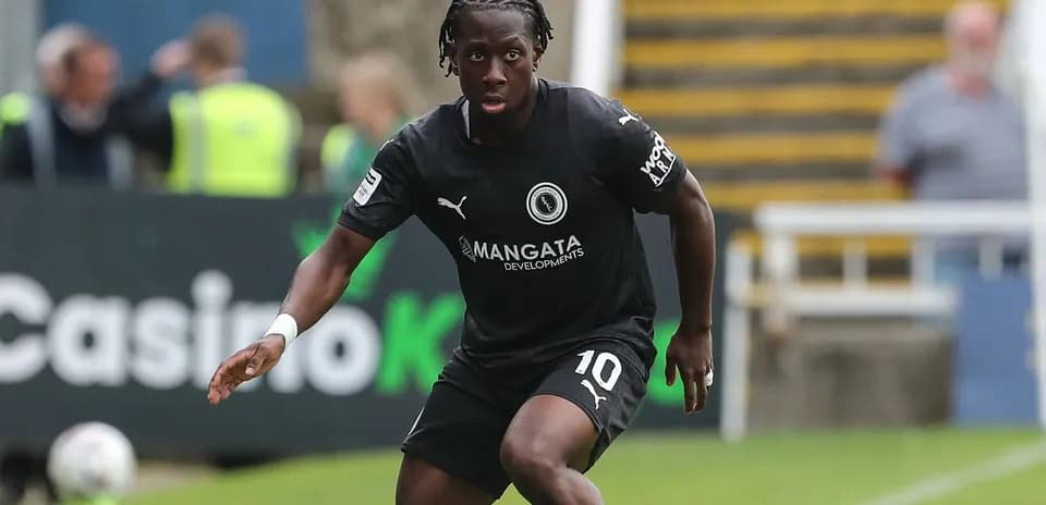 Jugador corriendo en campo durante un partido de fútbol