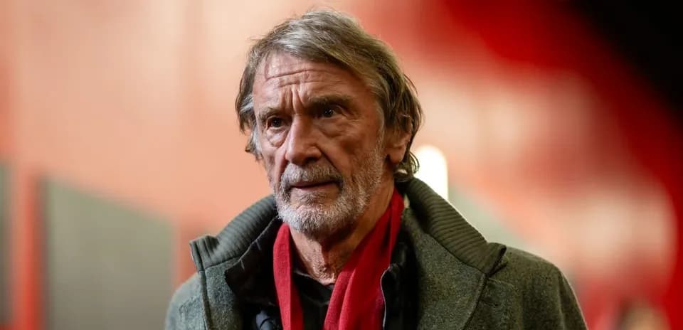 Hombre mayor con abrigo y bufanda roja en un pasillo