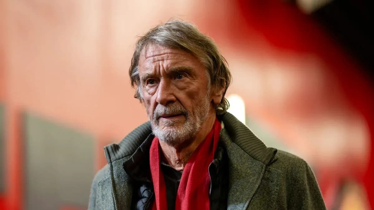 Hombre mayor con abrigo y bufanda roja en un pasillo