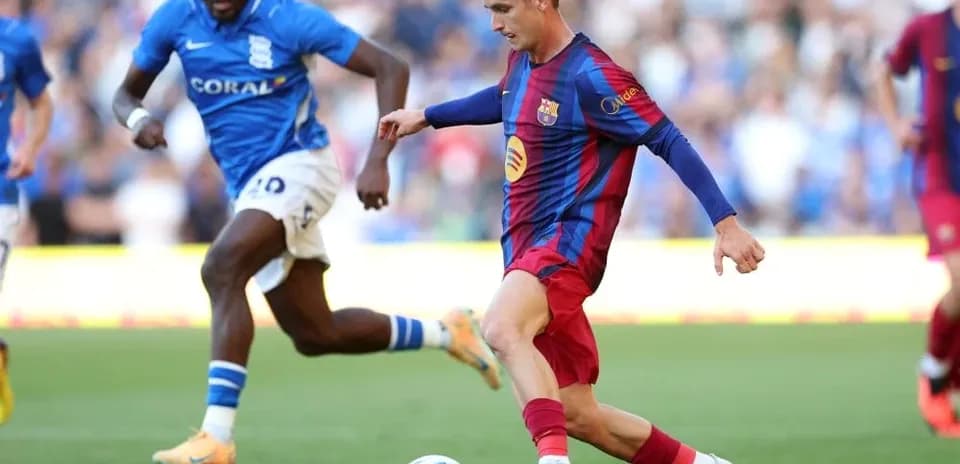 Jugador de Barcelona driblando mientras es perseguido