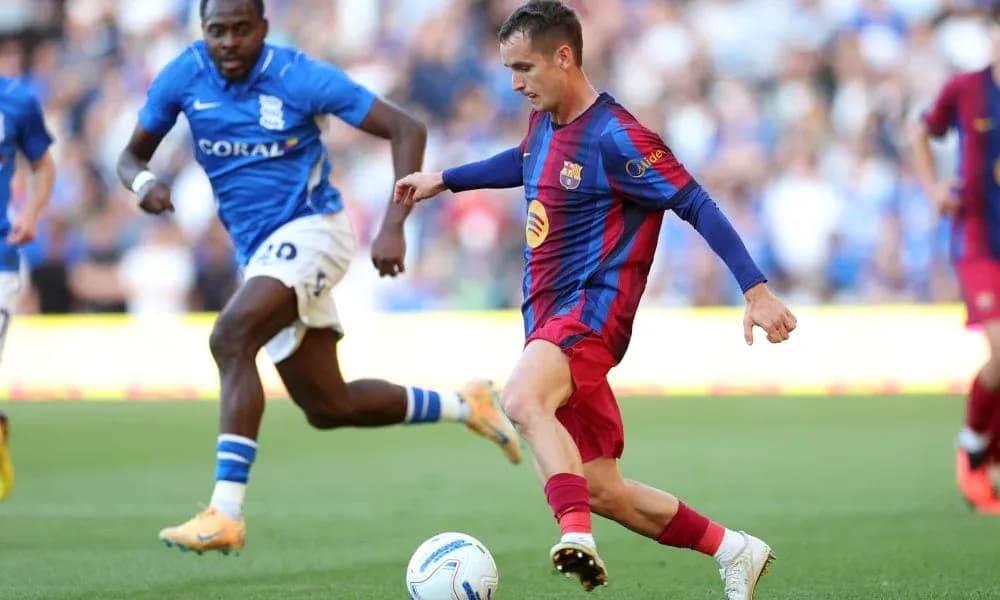 Jugador de Barcelona driblando mientras es perseguido