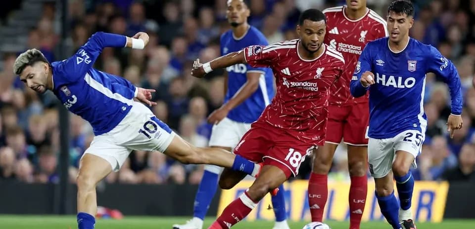 Jugador de Ipswich intentando driblar a Liverpool