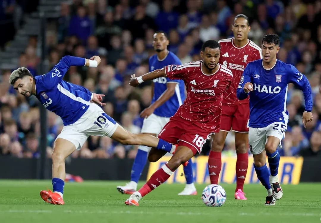 Jugador de Ipswich intentando driblar a Liverpool