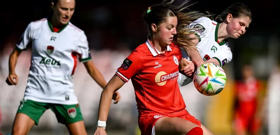 Jugadora con balón en partido de fútbol femenino