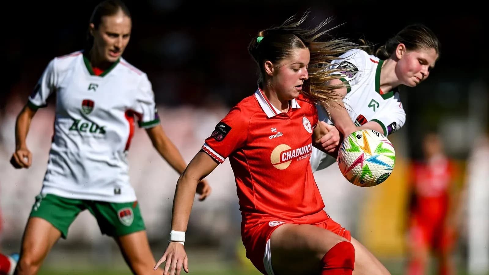 Jugadora con balón en partido de fútbol femenino