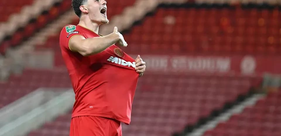 Jugador celebrando mientras sostiene su camiseta