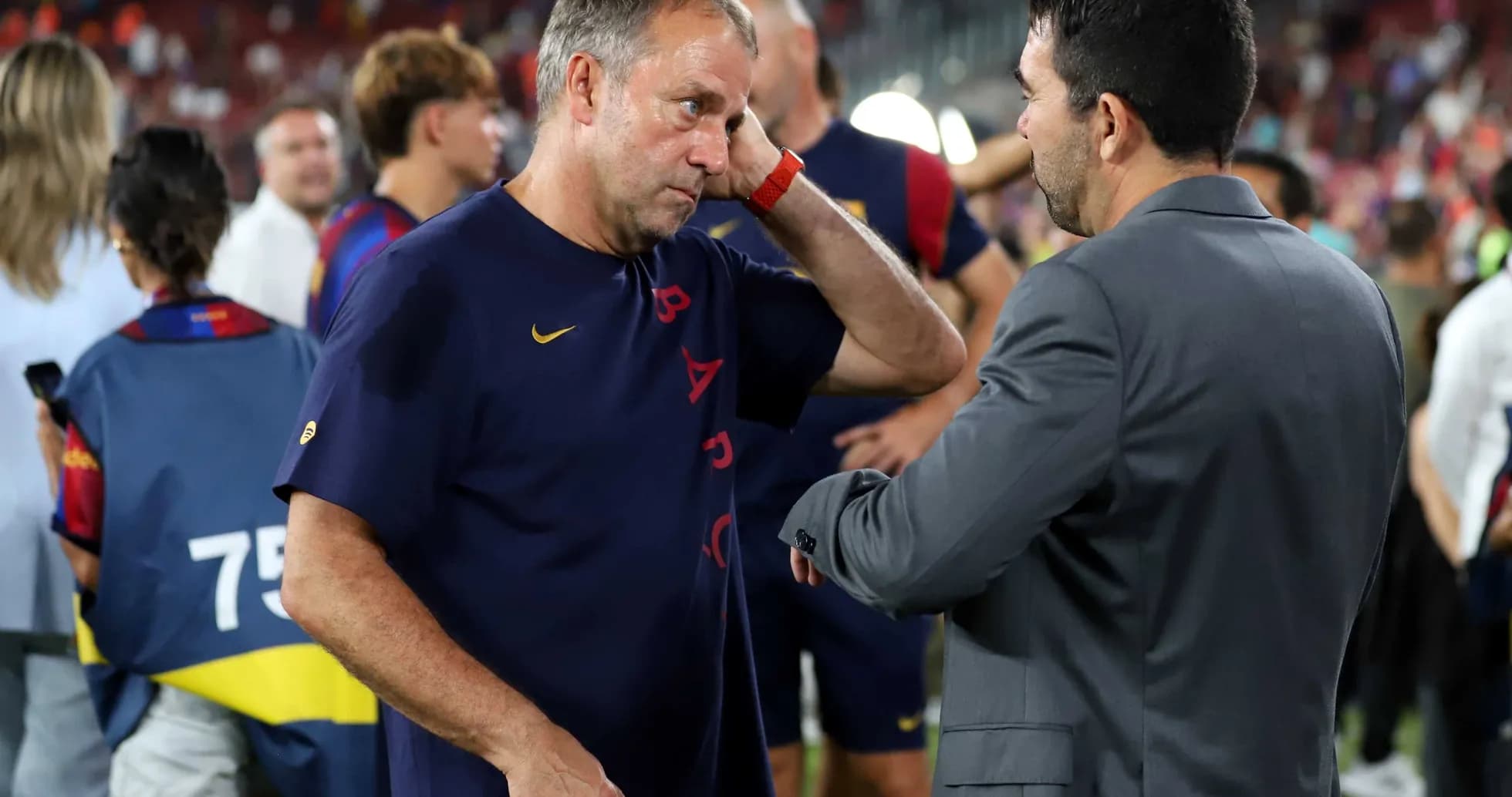 Entrenador conversando con otro profesional en el campo