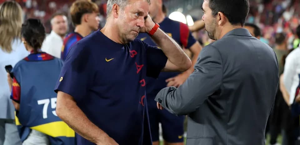 Entrenador conversando con otro profesional en el campo
