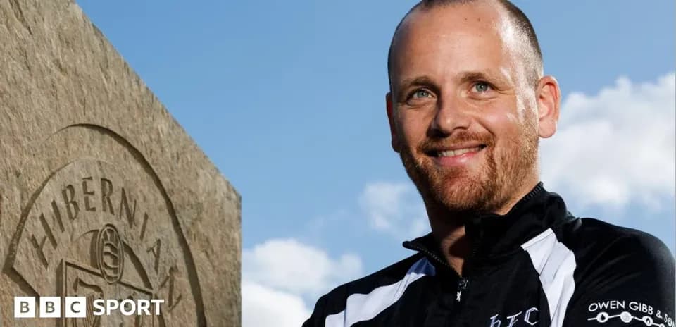 Hombre sonriendo junto a una piedra de Hibernian