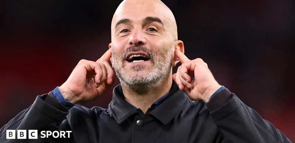 Entrenador señalando sus oídos durante el partido