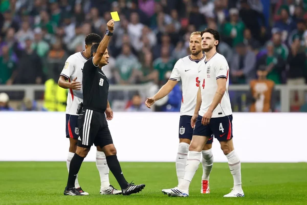 Árbitro mostrando tarjeta amarilla a jugador inglés