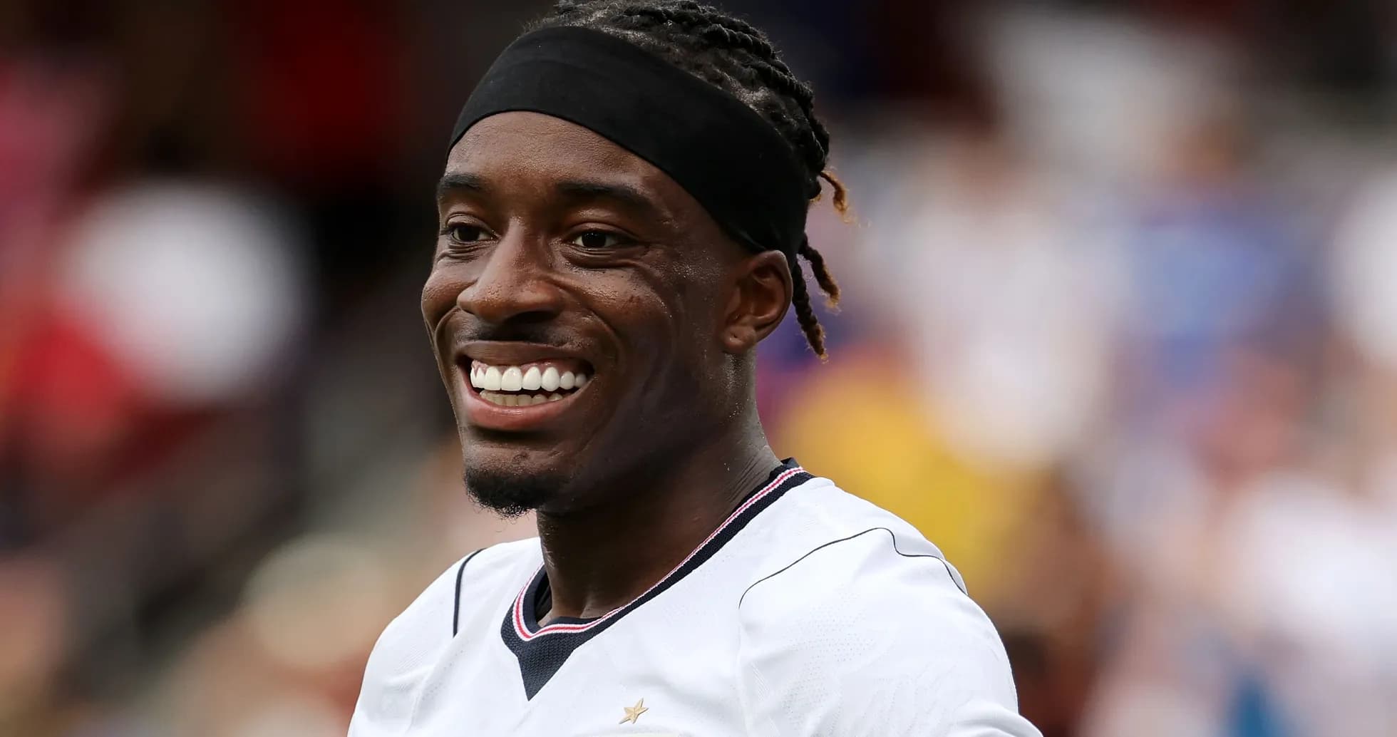 Jugador sonriente con camiseta blanca en el campo