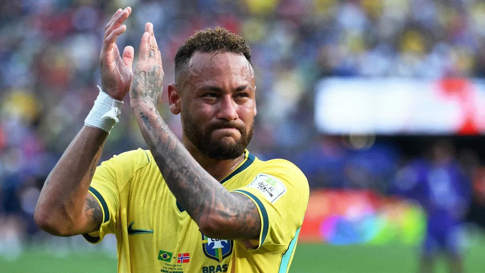 Jugador aplaudiendo en partido con camiseta amarilla