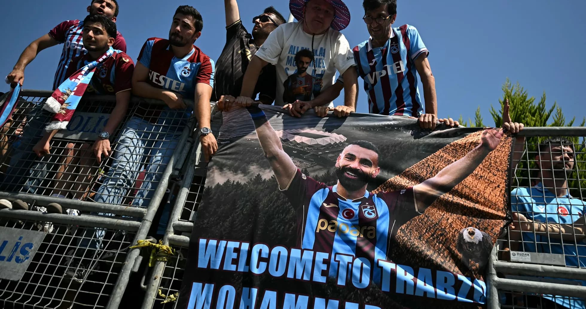 Aficionados con pancarta de bienvenida a jugador