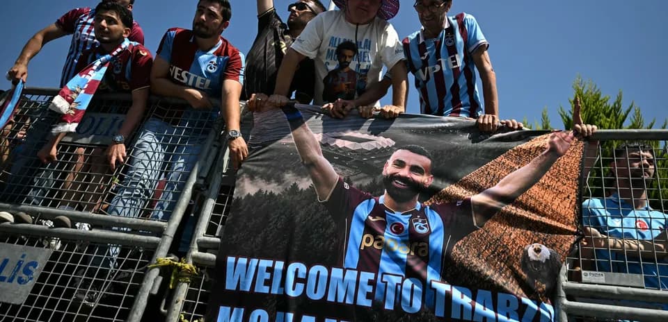 Aficionados con pancarta de bienvenida a jugador
