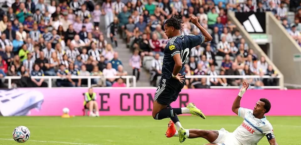 Jugador esquivando a oponente en partido de fútbol