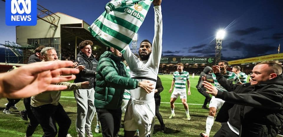 Jugador de Celtic levantando camiseta entre aficionados