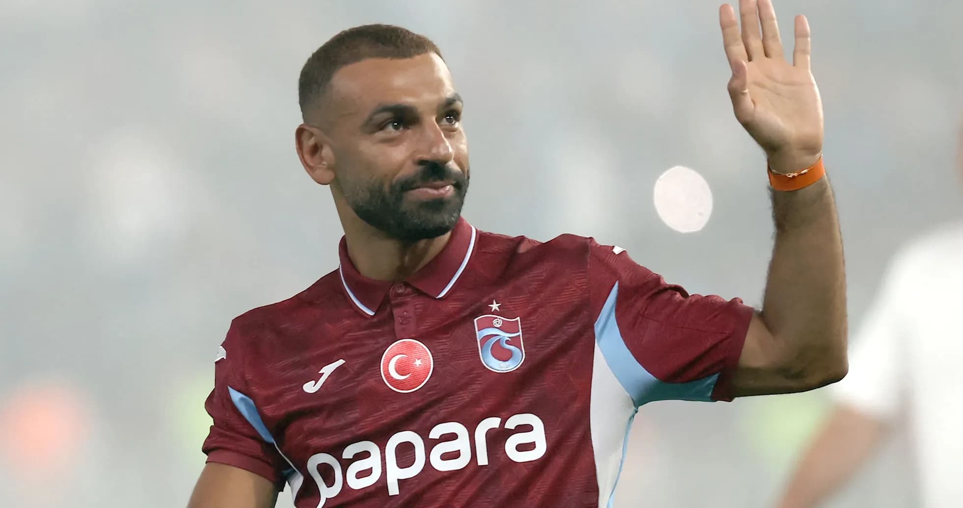 Jugador saludando con la mano en el campo Jugador saludando con la mano en el campo