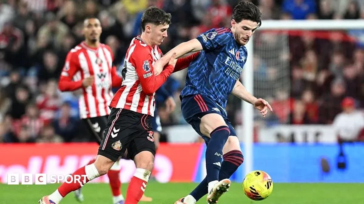 Jugador de Sunderland persiguiendo a jugador de Arsenal Jugador de Sunderland persiguiendo a jugador de Arsenal