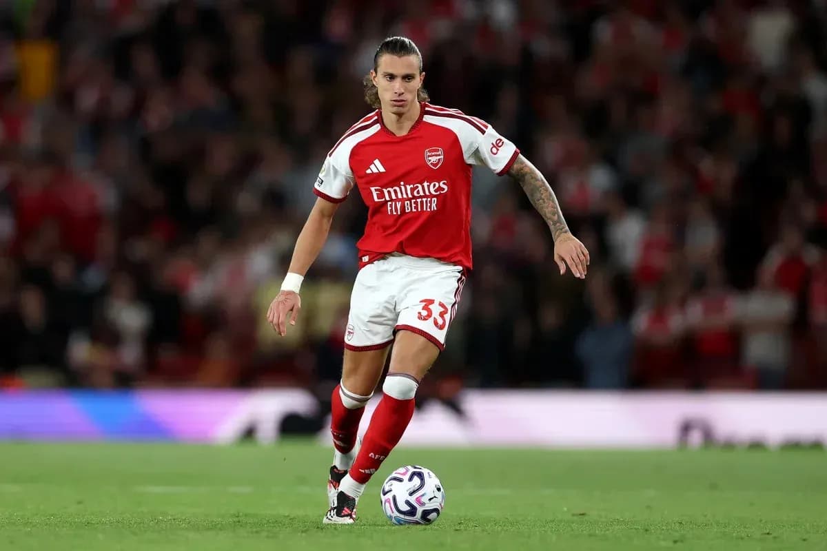 Jugador de Arsenal avanzando con el balón en el campo Jugador de Arsenal avanzando con el balón en el campo