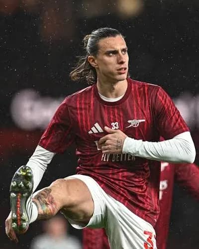Jugador de Arsenal ajustando su uniforme en el campo Jugador de Arsenal ajustando su uniforme en el campo