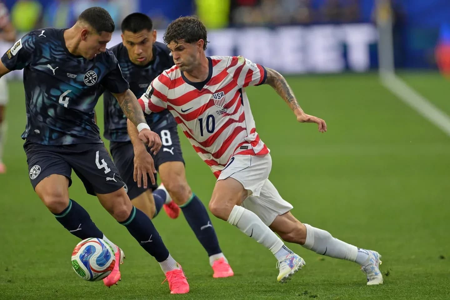 Christian Pulisic dribbling past opposing player Christian Pulisic dribbling past opposing player