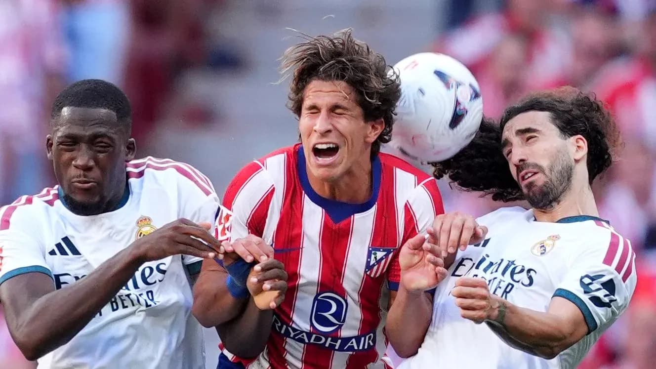 Jugadores de Atlético y Real Madrid disputando el balón Jugadores de Atlético y Real Madrid disputando el balón