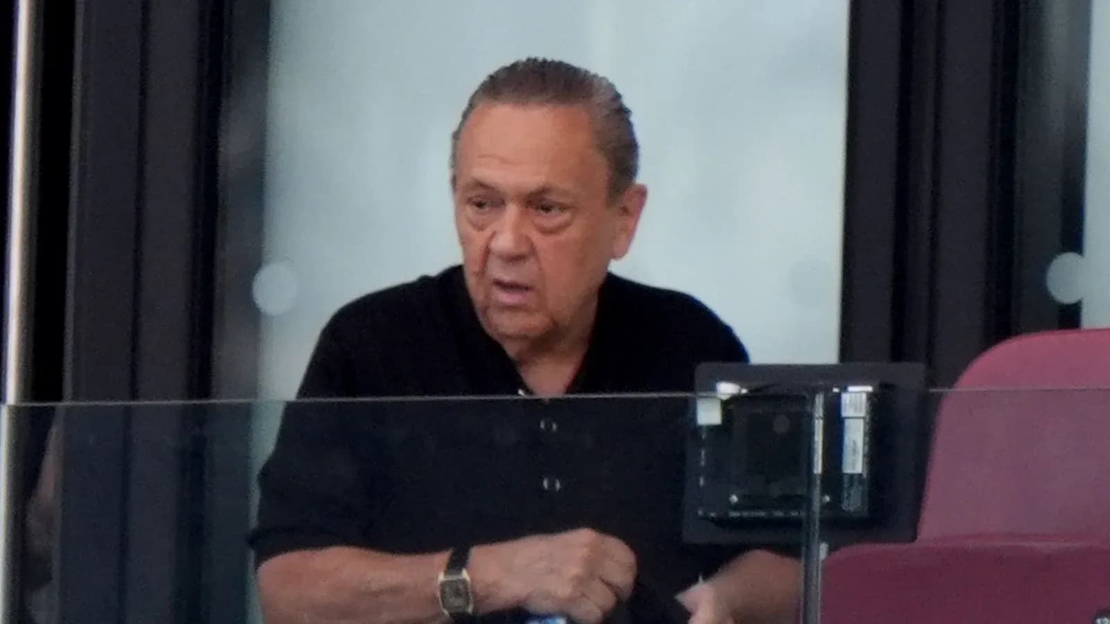 Hombre en un palco observando un evento deportivo Hombre en un palco observando un evento deportivo