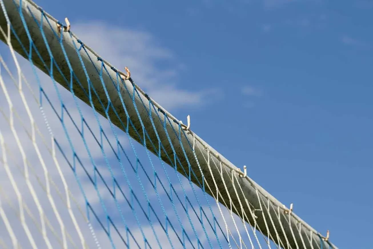 Red de un arco de fútbol contra cielo azul Red de un arco de fútbol contra cielo azul