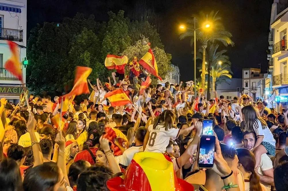 Multitud celebrando con banderas en la calle Multitud celebrando con banderas en la calle