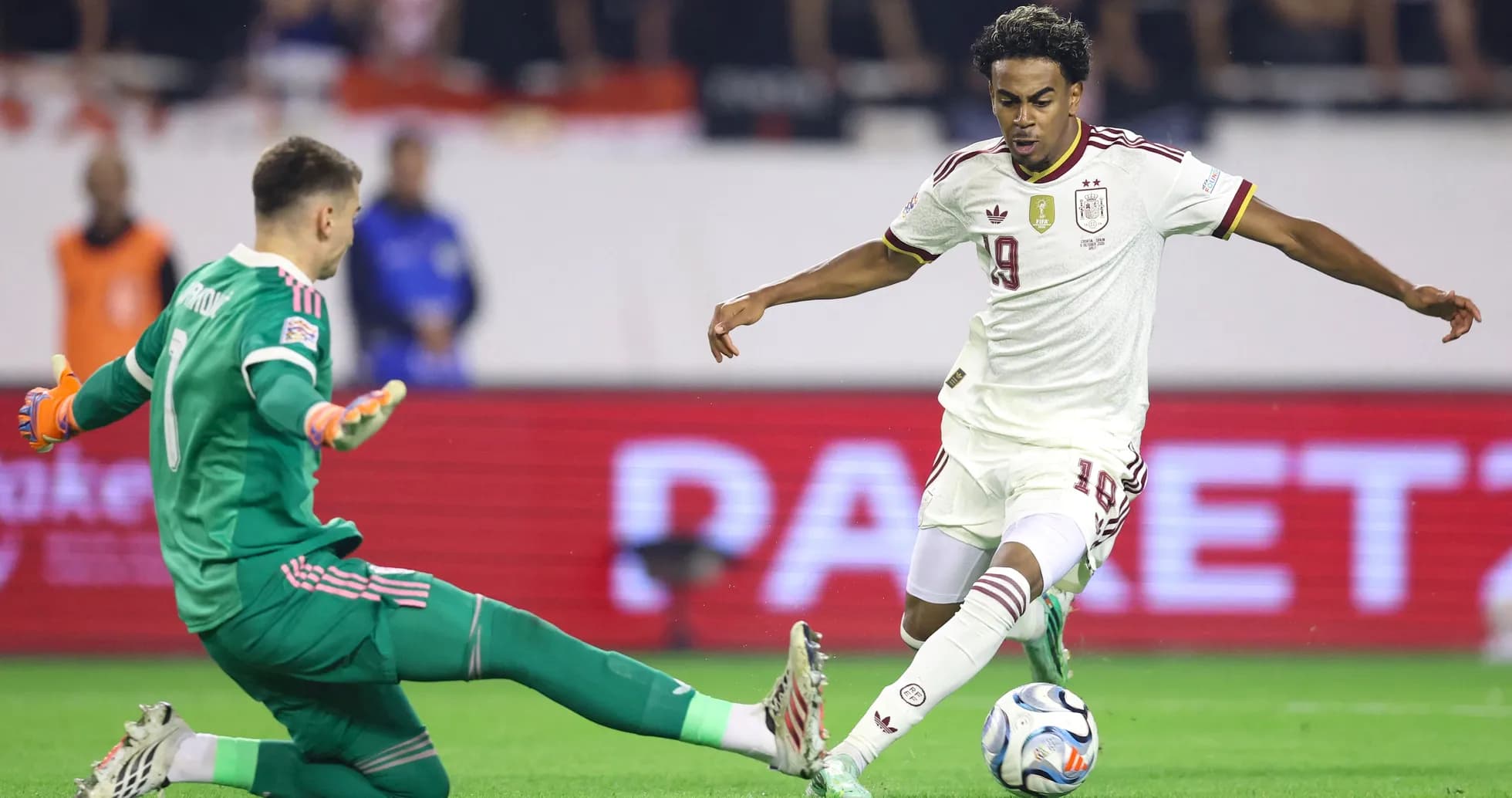 Jugador español esquivando al portero en el partido Jugador español esquivando al portero en el partido