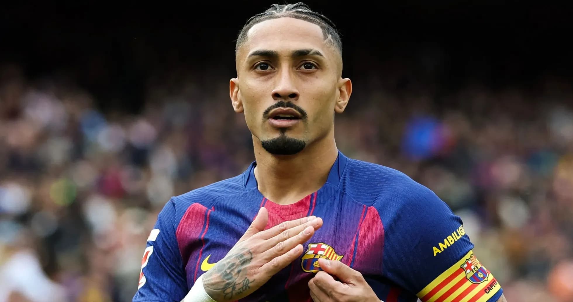 Jugador de Barcelona tocando el escudo del club Jugador de Barcelona tocando el escudo del club