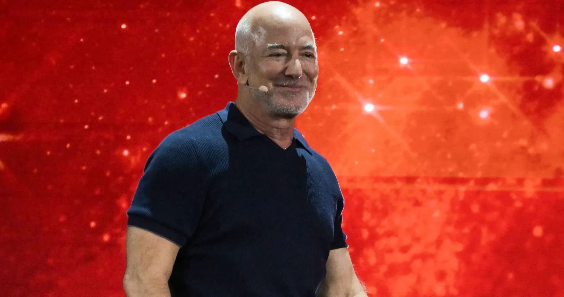 Hombre sonriendo en escenario con fondo rojo Hombre sonriendo en escenario con fondo rojo