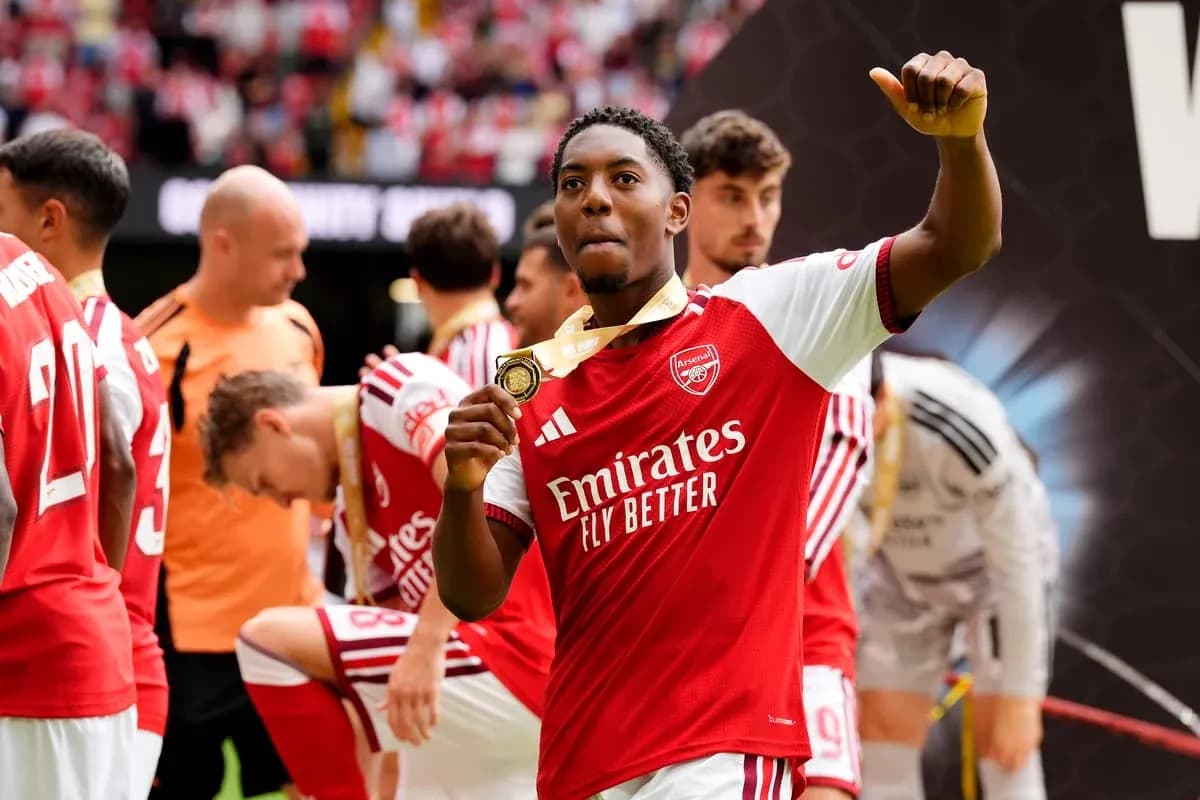 Jugador de Arsenal mostrando medalla de ganador Jugador de Arsenal mostrando medalla de ganador