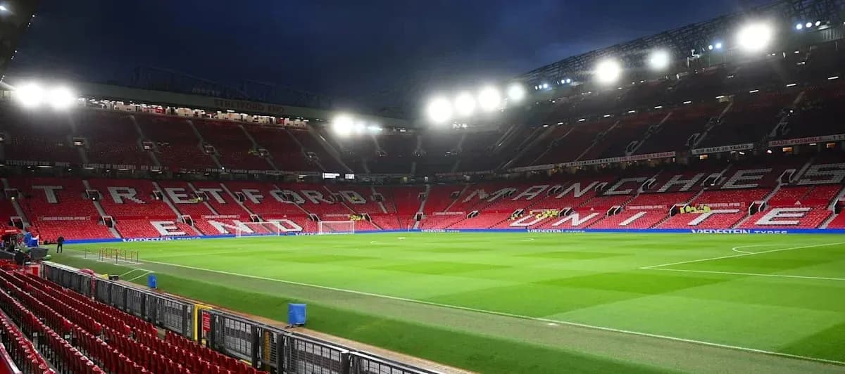 Estadio Old Trafford con asientos vacíos y césped Estadio Old Trafford con asientos vacíos y césped
