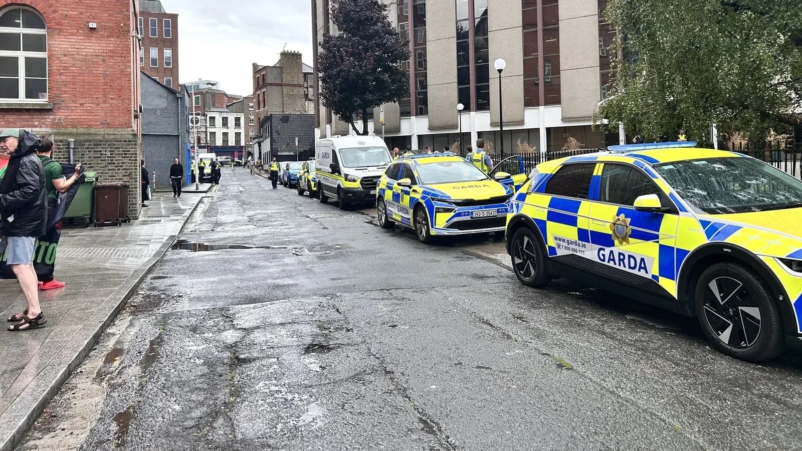 Vehículos de Garda estacionados en una calle lluviosa Vehículos de Garda estacionados en una calle lluviosa