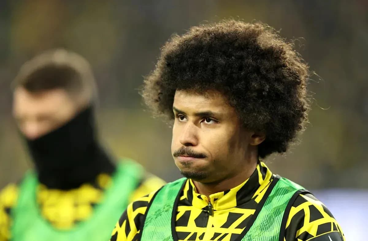 Jugador en el banquillo con uniforme amarillo y verde Jugador en el banquillo con uniforme amarillo y verde